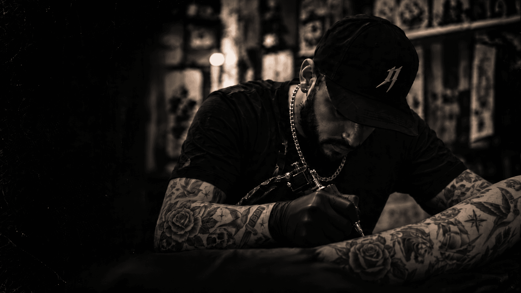 Tattoo artist concentrating on tattooing a client's arm.